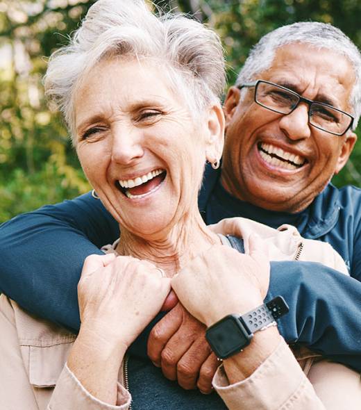 Hiking, laugh and romance with a senior couple hugging while in the woods or nature forest together in summer for a hike. Fun, joke and bonding with a mature man and woman enjoying retirement outdoor